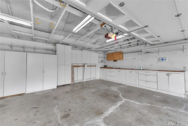 Spacious Garage For Three Vehicles.  Tons Of Cabinets, Shelving And Work Countertop  Rolluo Garage Doors Are Insulated!