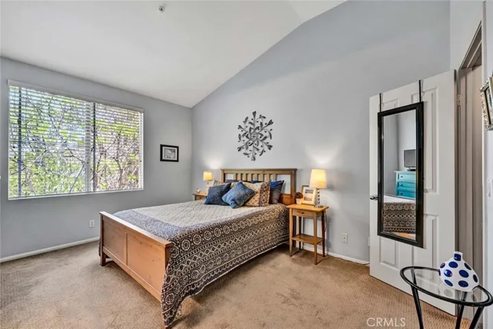 Large primary suite with vaulted ceilings and views of private park like scenic views.