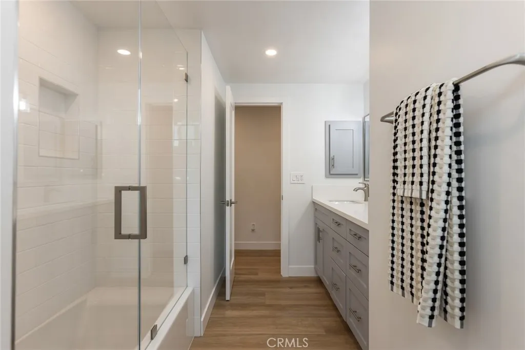 full shared bathroom with glass doors to bath tub