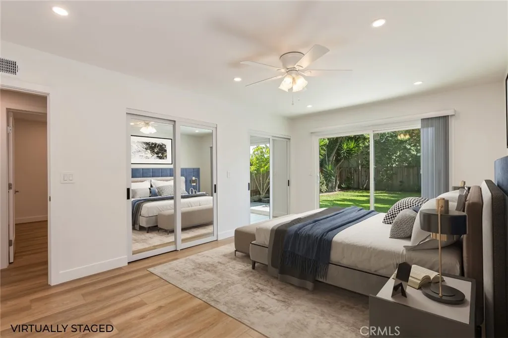 virtually staged primary bedroom with sliding glass door to the back yard