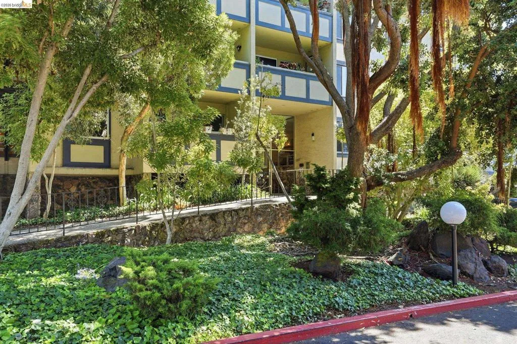 Manicured landscaping featuring lush ground cover, mature trees, and decorative rocks