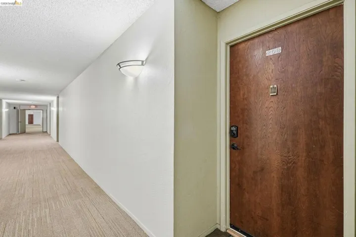 Entry door featuring wood-finish paneling and modern black hardware