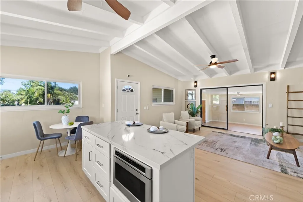 Microwave oven with a built-in shelf above, situated in a high-traffic area of the kitchen.  
