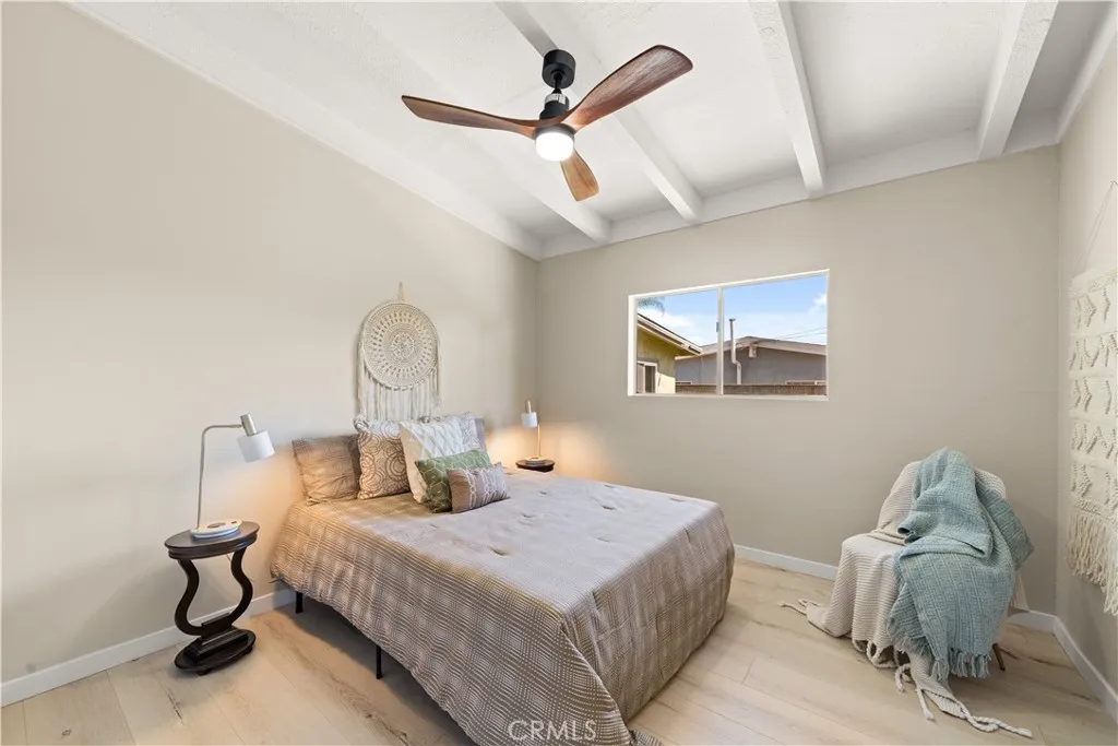 Guest bed with a large window and cieling fan for comfort.    
