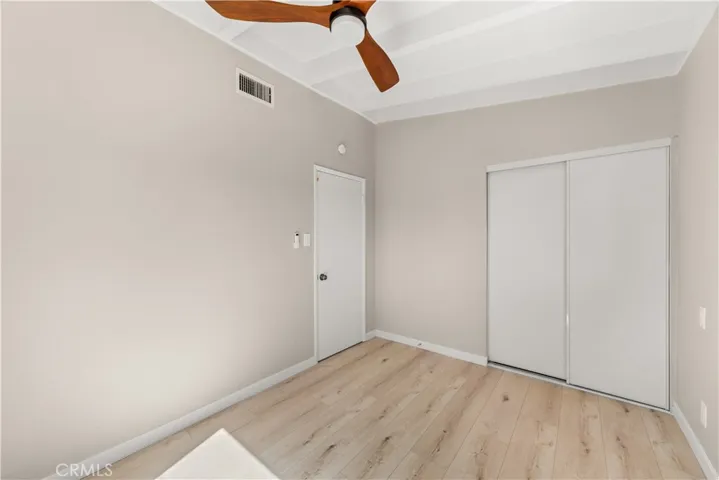 Guest bedroom with natural light, new paint, and beautiful flooring.