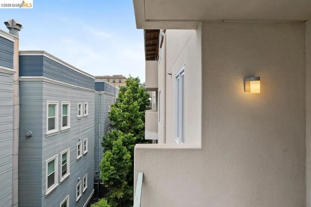 Exterior balcony with a contemporary wall sconce, stucco finish, and a painted metal railing Exterior balcony with a contemporary wall sconce, stucco finish, and a painted metal railing