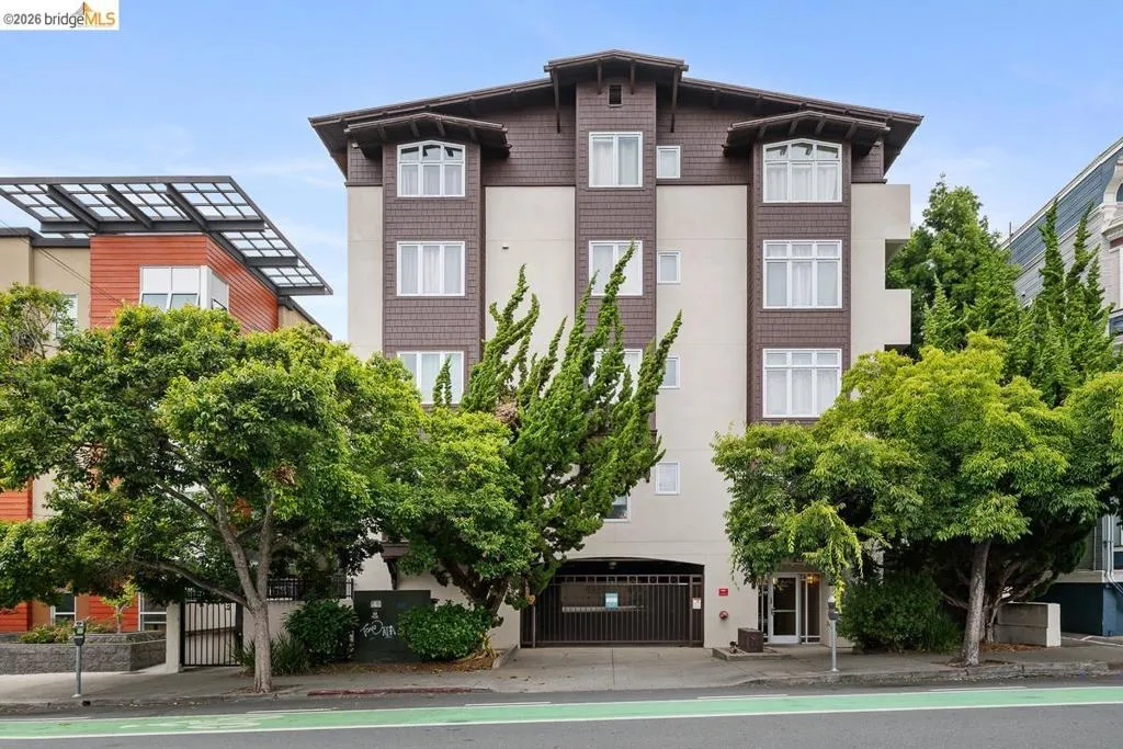 Multi-story building featuring a brown shingle and stucco facade with multiple windows Multi-story building featuring a brown shingle and stucco facade with multiple windows
