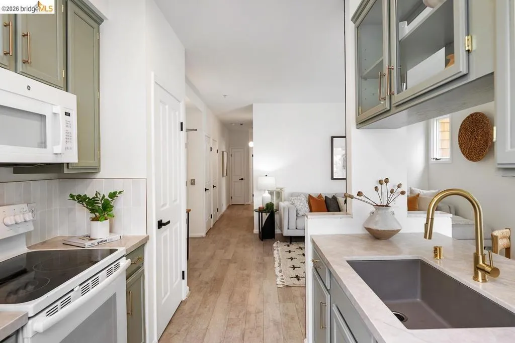 Kitchen featuring sage green cabinetry, a gold-finish faucet, and a large single-basin sink Kitchen featuring sage green cabinetry, a gold-finish faucet, and a large single-basin sink