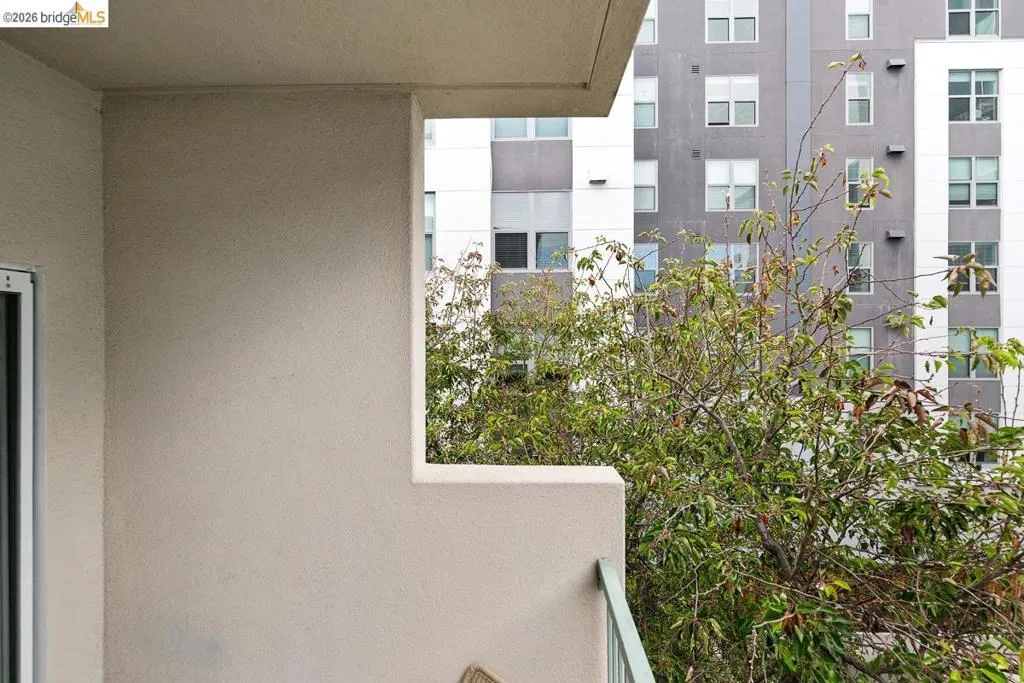 Balcony featuring a stucco exterior, a metal railing, and a sliding glass door Balcony featuring a stucco exterior, a metal railing, and a sliding glass door