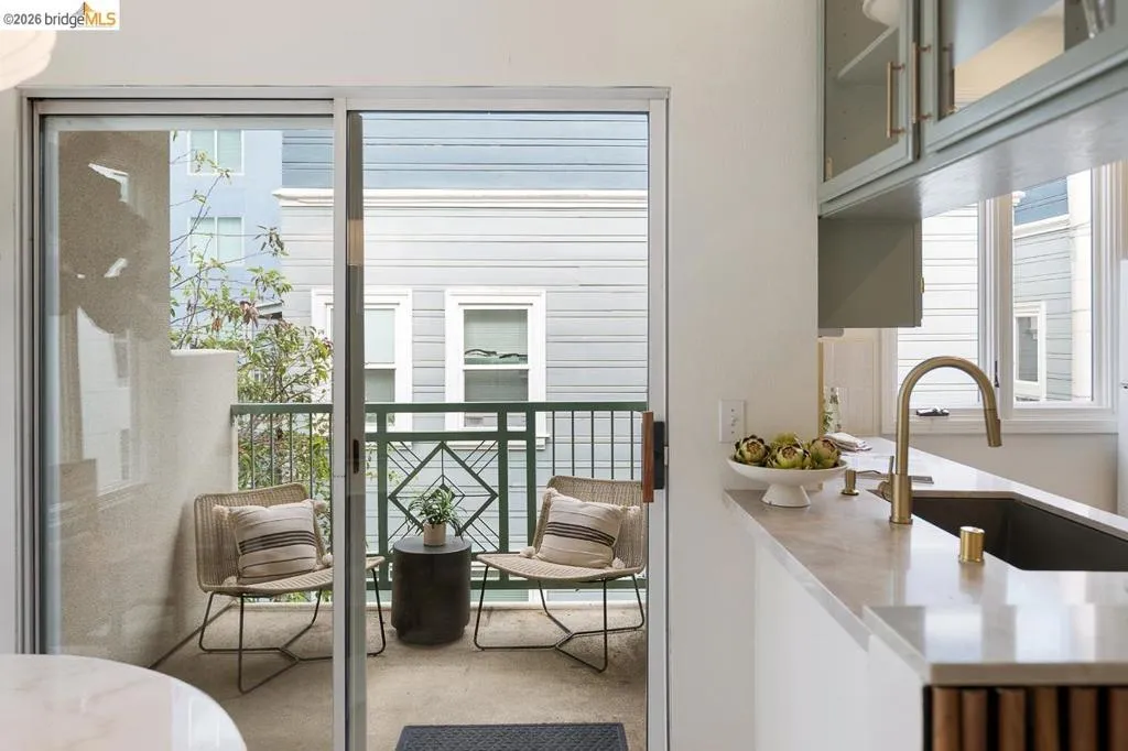 Balcony with sliding glass door access, featuring a decorative metal railing and concrete flooring Balcony with sliding glass door access, featuring a decorative metal railing and concrete flooring