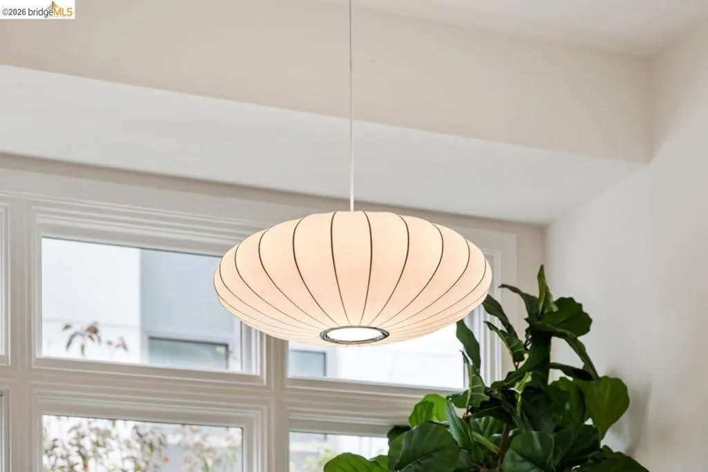 Modern ceiling-mounted pendant light with a white fabric shade and metal accents Modern ceiling-mounted pendant light with a white fabric shade and metal accents