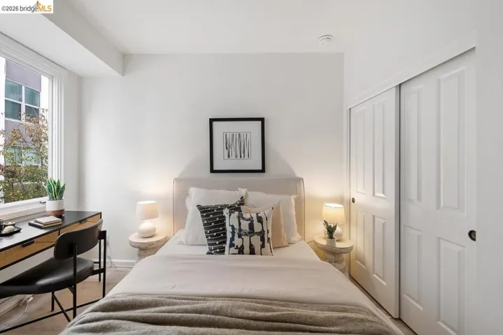 Bedroom featuring a large window, plush carpet flooring, and a built-in sliding panel closet