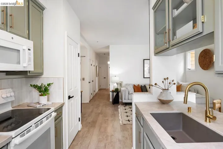 Kitchen featuring sage green cabinetry, a gold-finish faucet, and a large single-basin sink