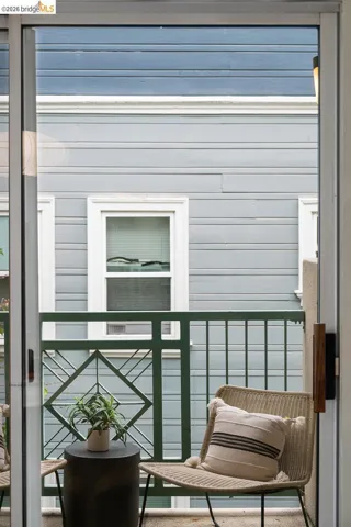 Sliding glass door opening to a private balcony featuring a decorative metal railing