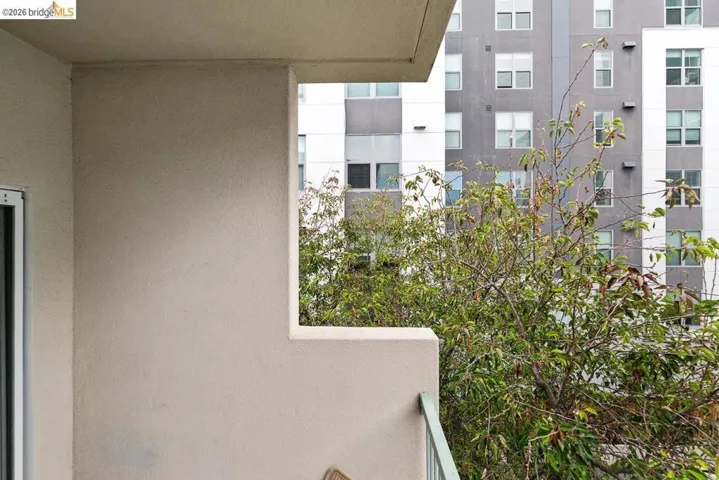 Balcony featuring a stucco exterior, a metal railing, and a sliding glass door