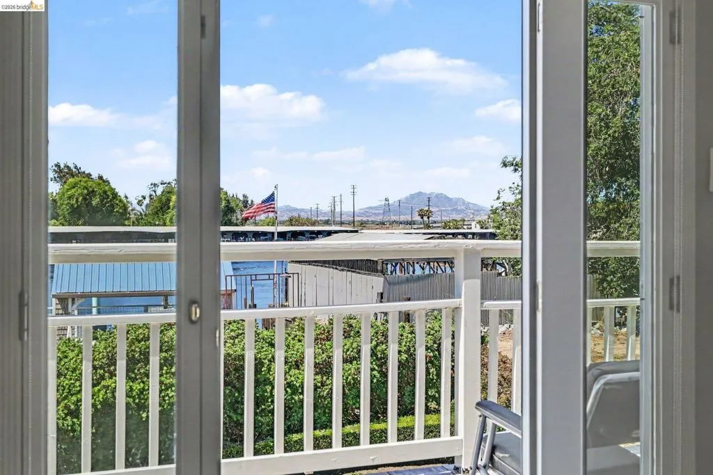 Balcony with white spindle railing and a mountain backdrop