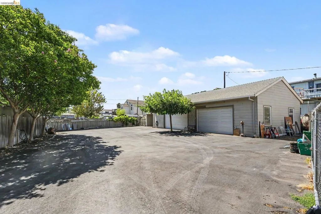 Expansive paved lot featuring a detached garage with two overhead doors