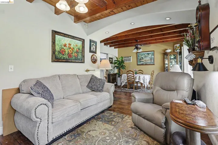 Living area featuring exposed wood beam ceilings and wood-finish flooring