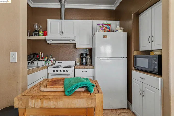 Kitchen featuring white cabinetry, a white electric range, and a white refrigerator