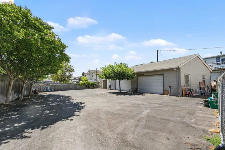 Expansive paved lot featuring a detached garage with two overhead doors