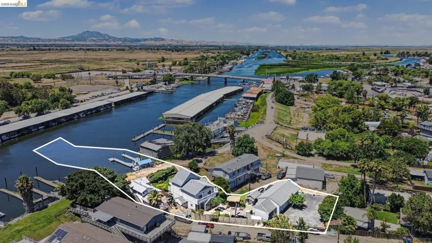 Waterfront property featuring a private boat dock, direct water access, a main residence, and additional outbuildings