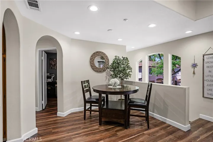 DINING AREA FEATURING LVP FLOORING, RECESSED LIGHTING, AND AN OPEN-CCONCEPT DESIGN OVERLOOKING THE ENTRY.