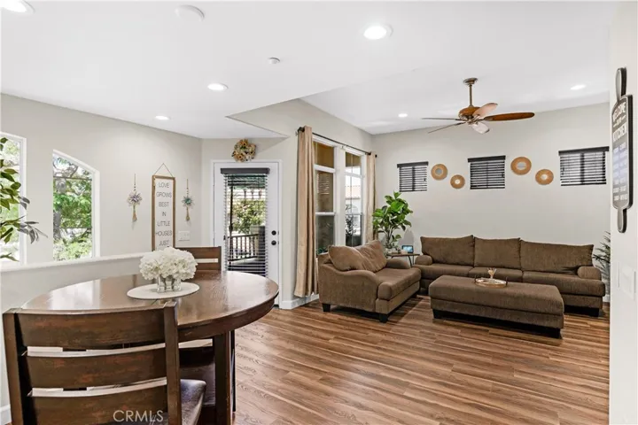 OPEN-CONCEPT DINING AND FAMILY ROOM FEATURING LVP FLOORING, RECESSED LIGHTING, CEILING FAN, AND DIRECT ACCESS TO THE PRIVATE BALCONY.