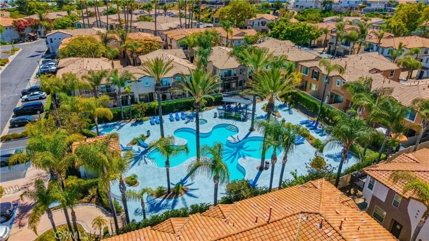 AERIAL VIEW SHOWCASING THE COMMUNITY'S BEAUTIFULLY LANDSCAPED RESORT-STYLE POOL AND TROPICAL SURROUNDINGS.