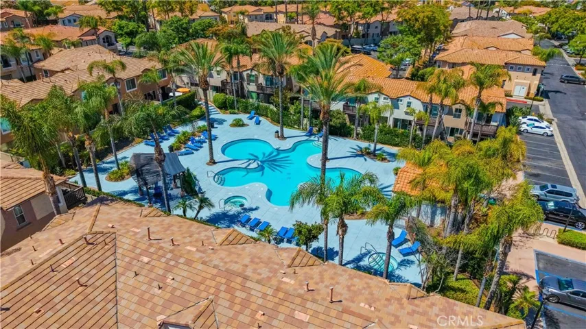 AERIAL VIEW OF THE COMMUNITY'S RESORT-STYLE POOL SURROUNDED BY MATURE PALM TREES AND LUSH LANDSCAPING.