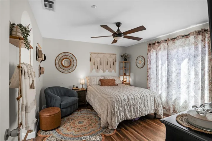 SPACIOUS PRIMARY BEDROOM WITH CEILING FAN, LVP FLOORING AND ABUNDANT NATURAL LIGHT.