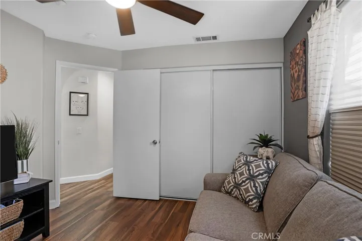 SECONDARY BEDROOM WITH CEILING FAN, CLOSET, AND LVP FLOORING.