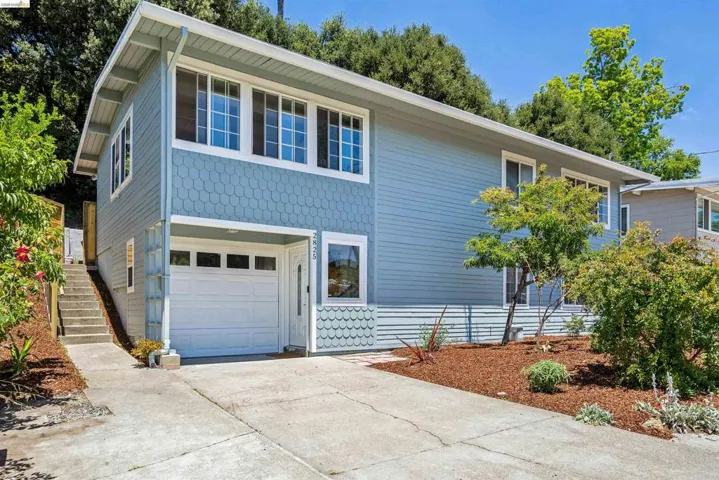 Two-story residence featuring light blue siding and decorative shingles