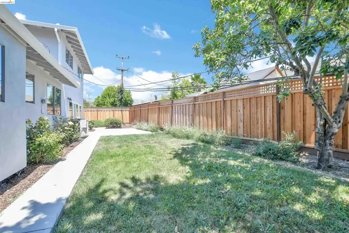 Expansive lawn area bordered by a new wood fence with lattice top