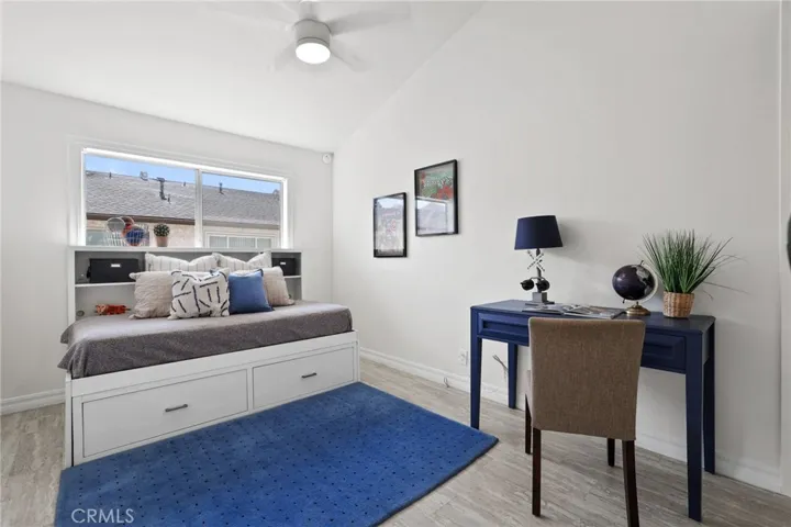 Guest bedroom is spacious with high ceilings, ceiling fan and light.