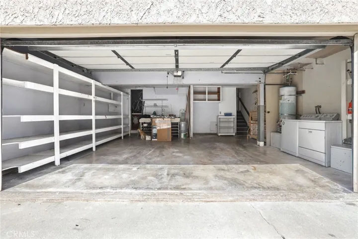 2-car garage with built in shelves and a storage room.
