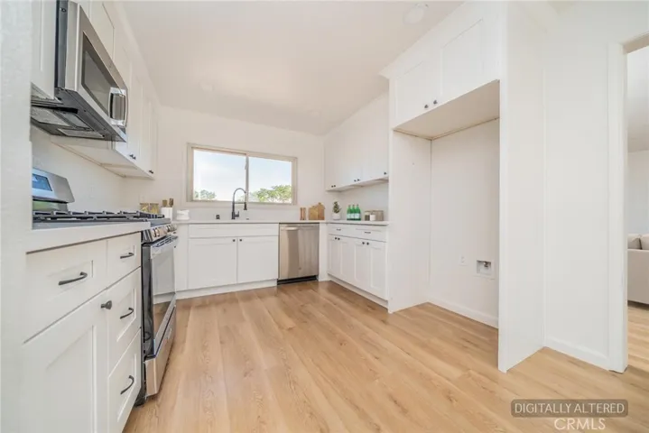 Remodeled Kitchen with new stainless appliances (Disclaimer: Some images have been digitally enhanced with virtual staging to illustrate potential room layouts and furnishings. Actual property condition and features may vary. Buyer to verify all information independently).