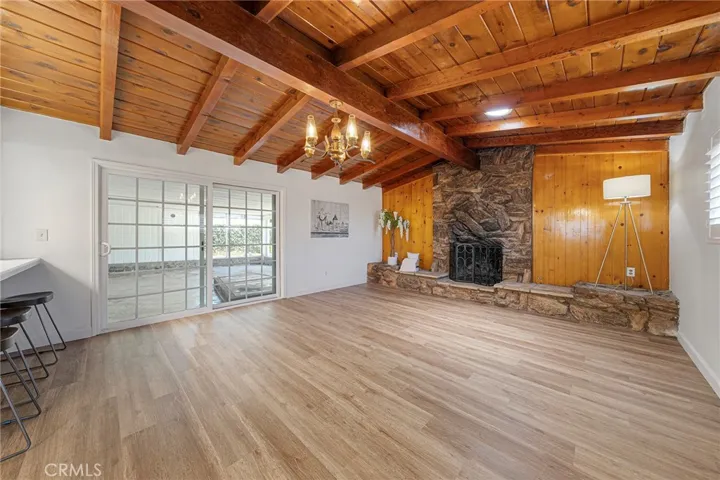 VVery spacious family room with rustic charm having beamed ceilings, rock fireplace, and wood walls help create a warm and inviting room to enjoy. Sliders to the covered patio. Newly painted and newly installed vinyl plank​​‌​​​​‌​​‌‌​​‌​​​‌‌​​​‌​​‌‌​​‌‌​​‌‌​​​​ flooring.
