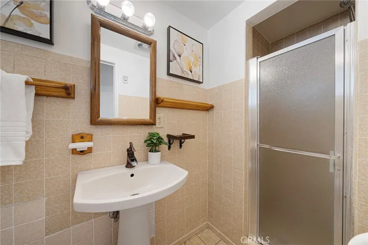 Primary bathroom with shower and pedestal sink.