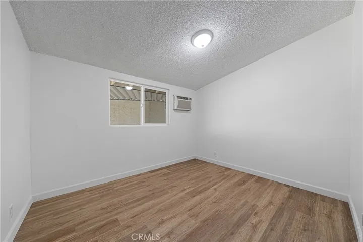 This bedrooms is two of three and located on the first left side of the hallway. Breezeway is seen through the windows. Wall AC right side of window. Newly painted and newly installed vinyl plank flooring.