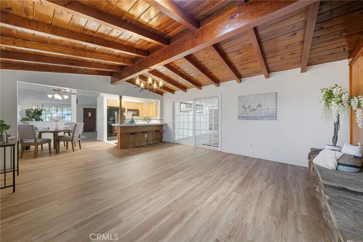 Roomy family room with beamed ceilings and flows to dining and kitchen area. Sliders to covered patio. Newly painted and newly installed vinyl plank flooring.