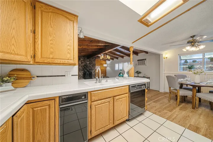 Kitchen opens to family room with beamed ceilings and dining area.