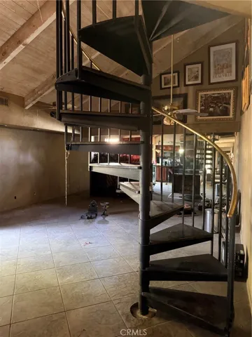 Stairs to bonus storage or flex area featuring a mirrored hall wall.