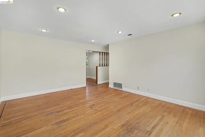 Spacious interior with wood-finish flooring, recessed lighting, and light-toned wall paint
