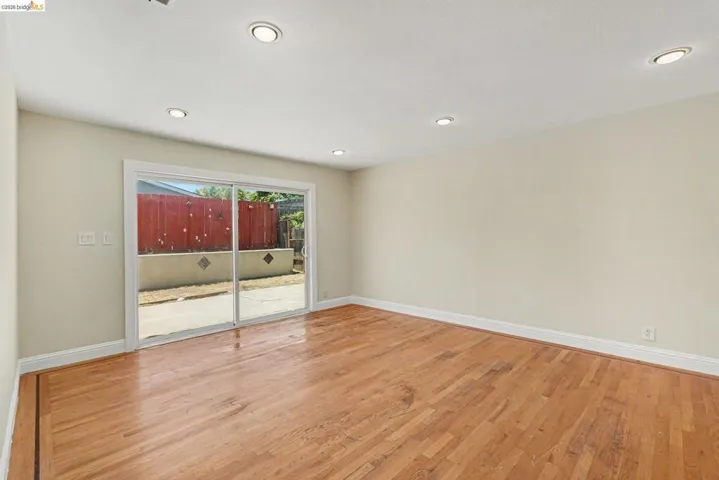 Hardwood flooring, recessed lighting, and light-toned walls with white baseboards