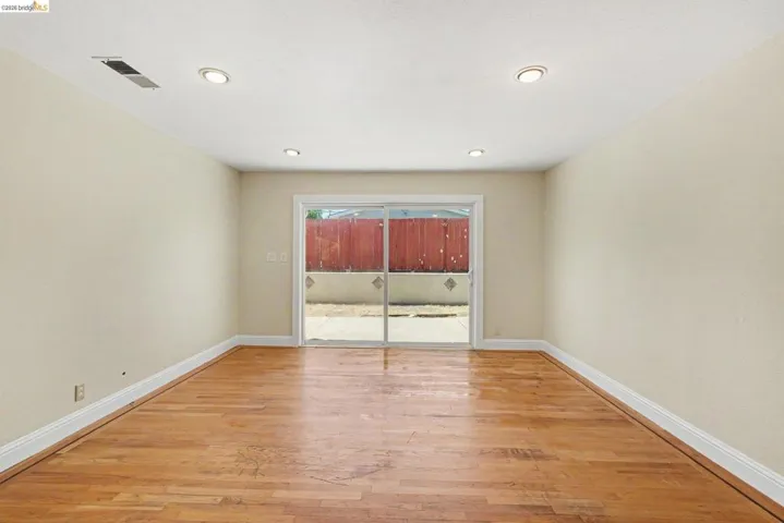 Room featuring wood-finish flooring, recessed lighting, and a sliding glass door