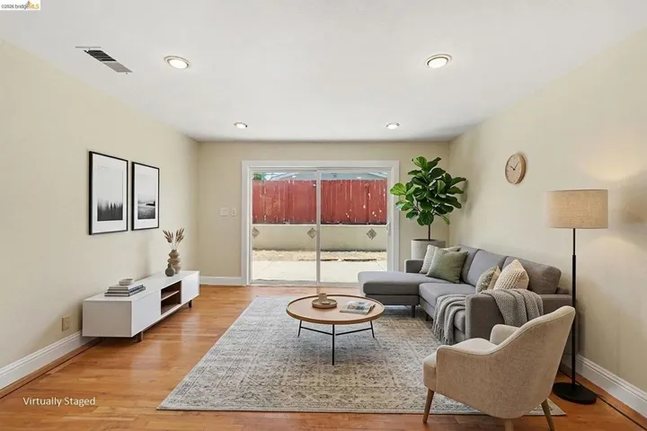 Spacious room featuring wood-finish flooring, recessed lighting, and light-toned walls