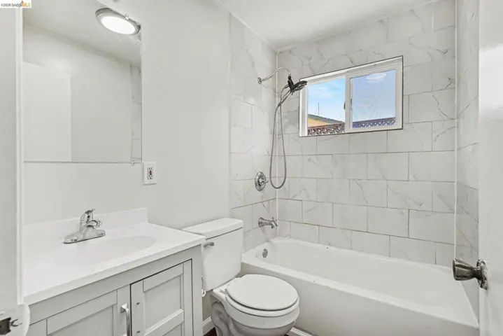 Bathroom featuring a white vanity with a single basin sink, chrome faucet, and under-sink storage