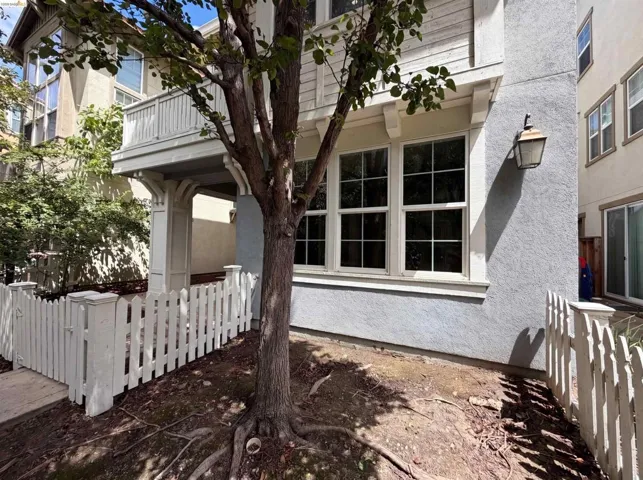 Exterior facade featuring a white picket fence, a covered porch with decorative columns, and a second-story balcony