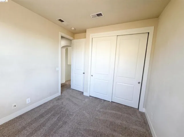 Plush carpet flooring, neutral painted walls, and white trim throughout