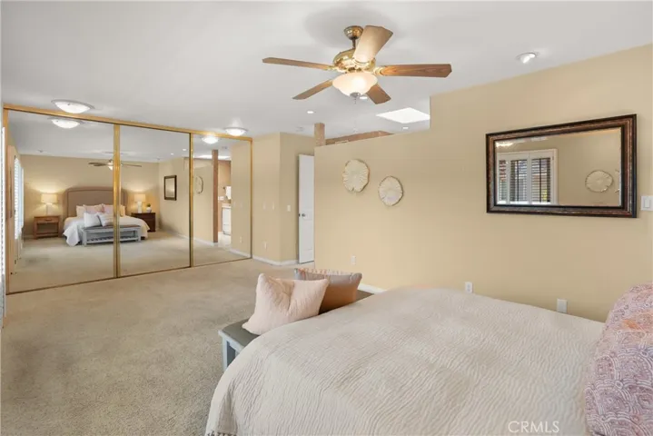 Main bedroom with mirror closet doors and sky light